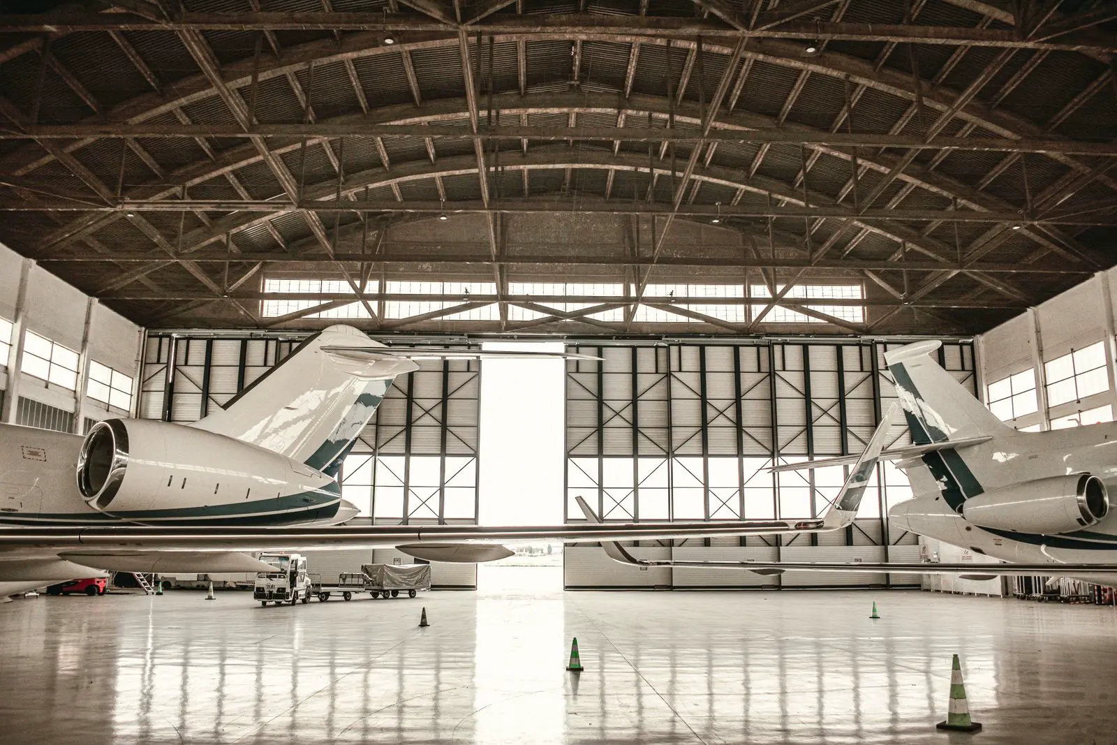 Business jets at rest in a quiet hangar — scale of the super-midsize class, not a fleet list.